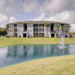 exterior of building with green turf and some seating